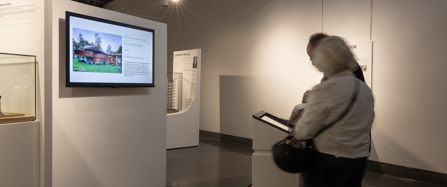 20250820-152235-THM-TodmordenMills-CanadianMuseumOfArchitecture-AndrewWilliamson-6993 Visitors interacting with a digital activity at the exhibition.